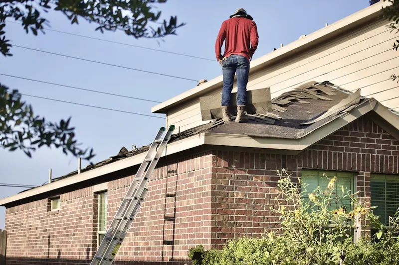Professional roofer working on a residential roof in Douglass Hills